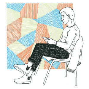 Junger weißer Mann mit kurzem hellem Haar, in Pullover, Jeans, und Sneakern, sitzend auf einem Stuhl mit seinem Smartphone